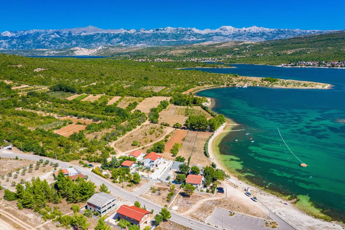 Obala Novigradskog mora kod Pridrage s Velebitom u pozadini