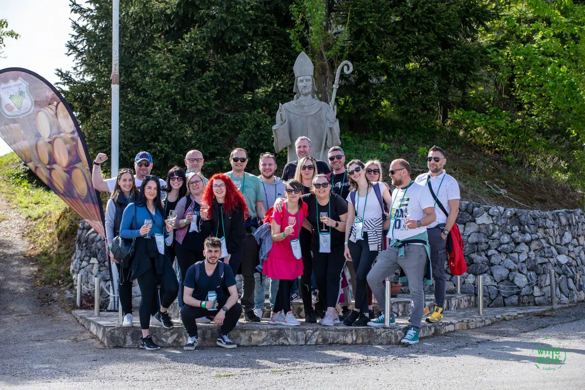 Velika grupa sudionika okupljena ispod kipa na brežuljku