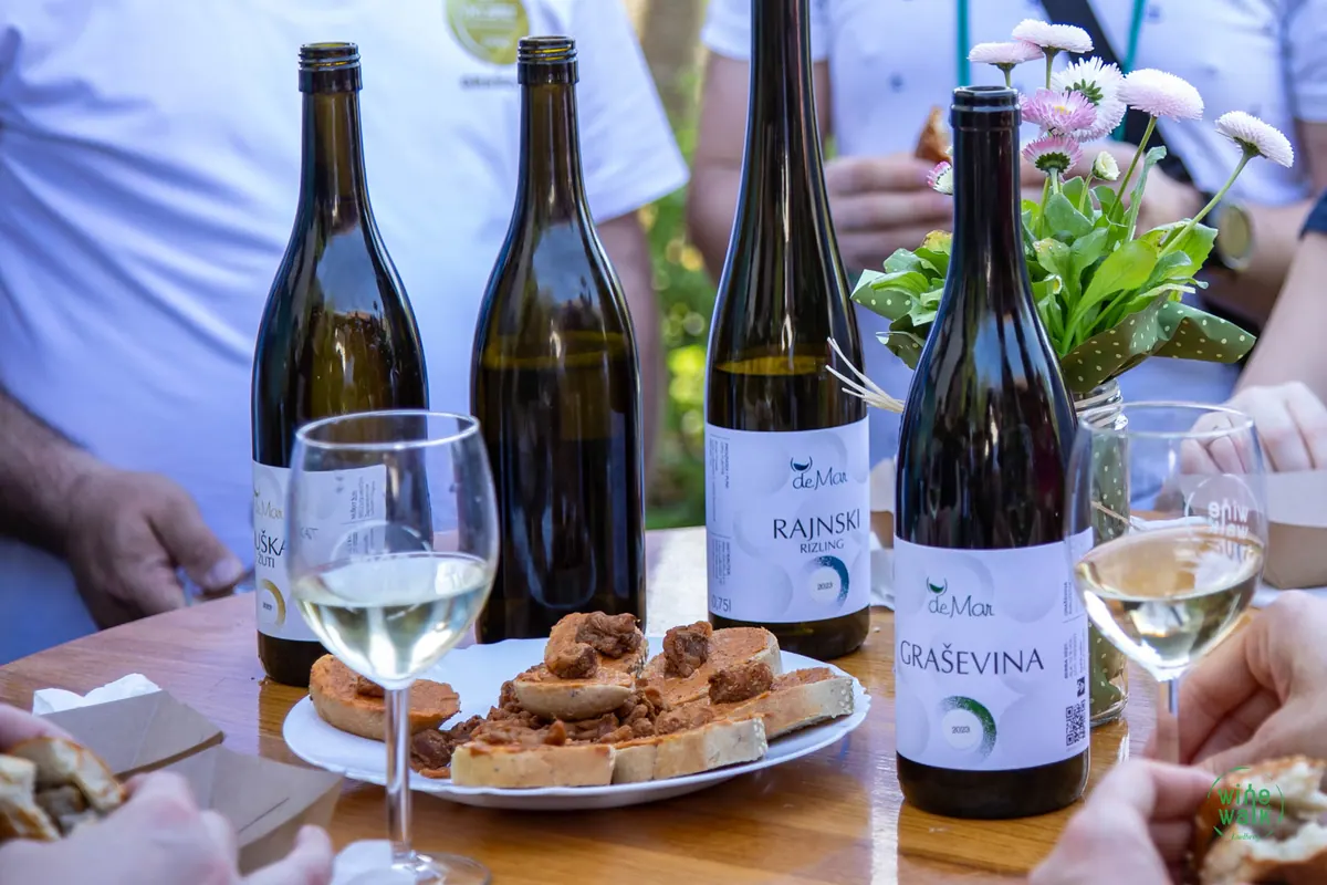 Boce vina, čaše i domaći slanci na stolu punkta